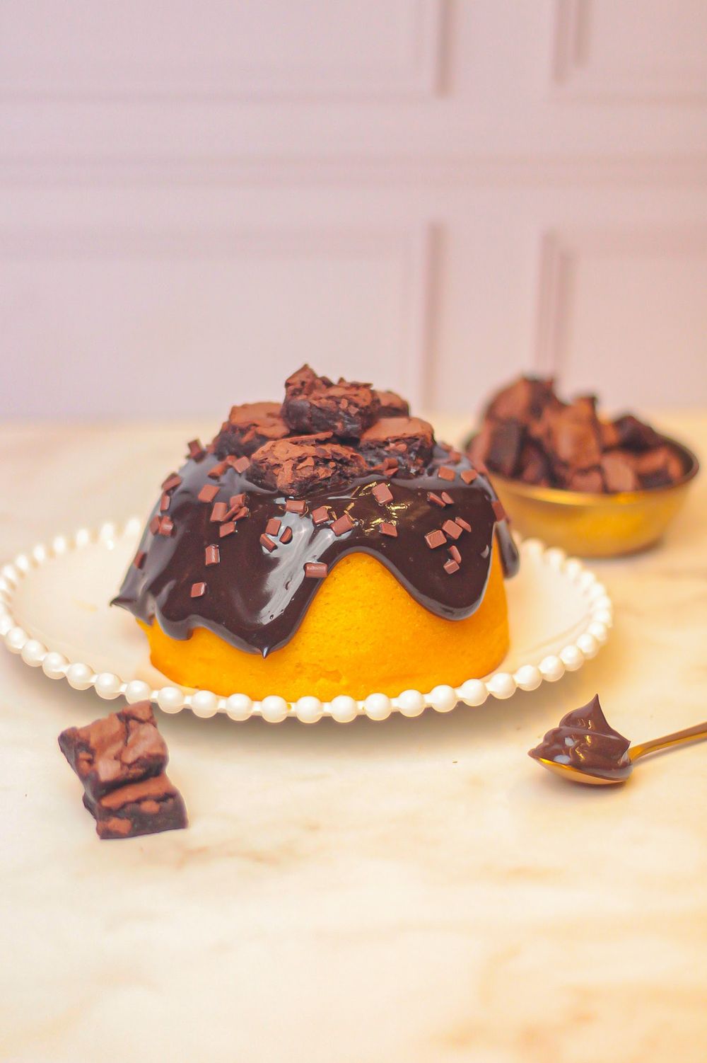 Doce redondo com cobertura de chocolate e pedaços de brownie