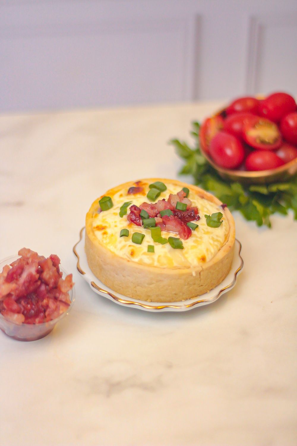 Torta com bacon e cebolinha ao lado de tomates